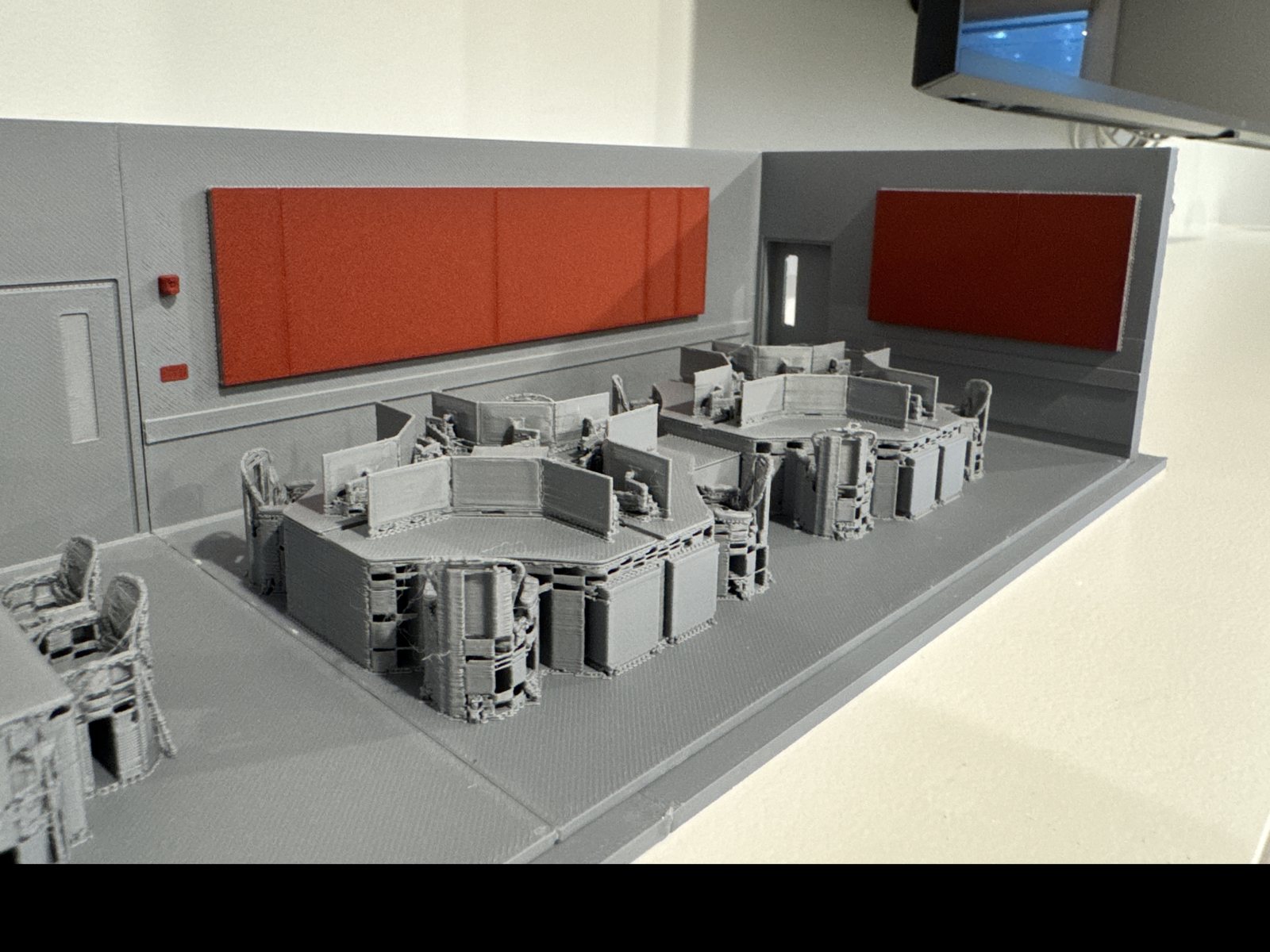 3D-printed scale model of the command centre with workstation pods and display wall